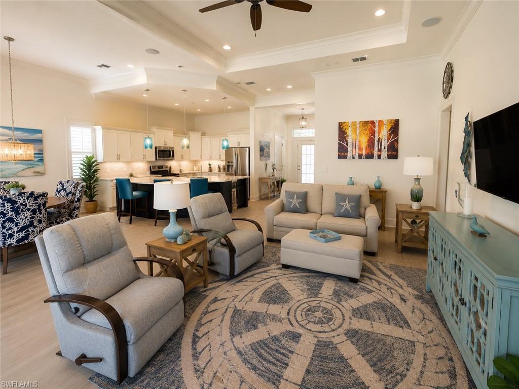 6574 Amarone Lane Naples, FL 34113 - Photo 12 of 44 a living room with furniture and a flat screen tv