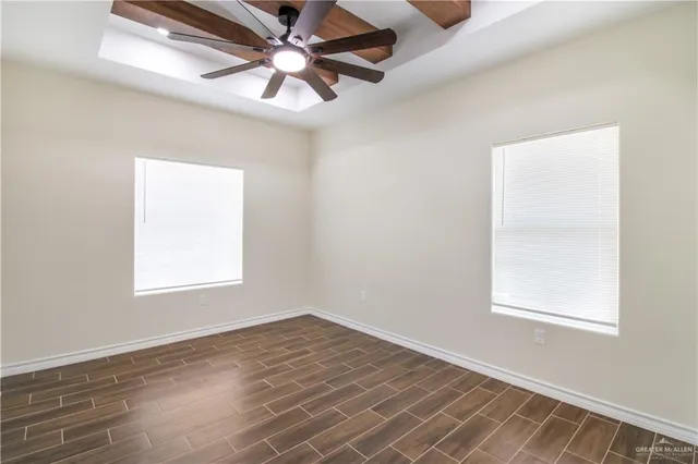 an empty room with a window and a fan