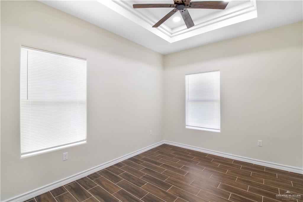 2126 Trinity Street Donna, TX 78537 - Photo 9 of 15 an empty room with wooden floor fan and windows