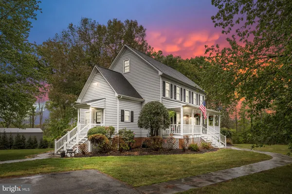 a front view of a house with a yard and trees
