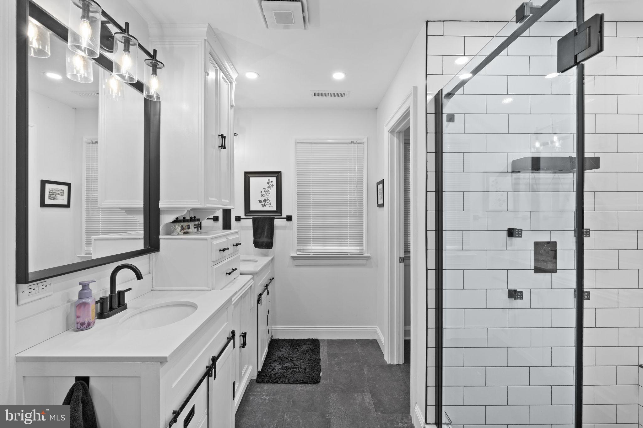 1942 Bibb Store Road Louisa, VA 23093 - Photo 26 of 61 a bathroom with a double vanity sink a mirror and shower
