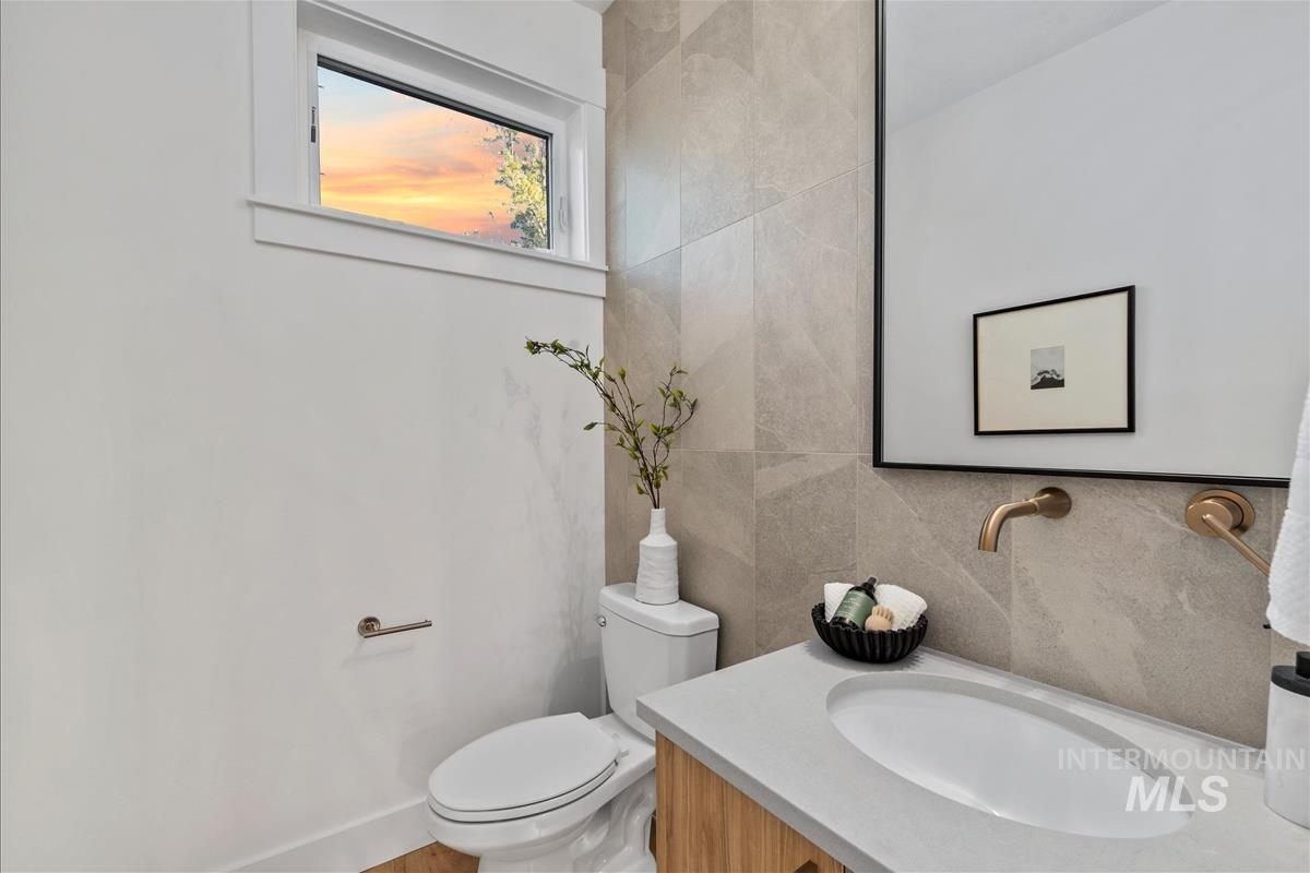 3255 West Moore Street Boise, ID 83702 - Photo 10 of 44 Half bathroom with vanity, tile walls, and tasteful backsplash