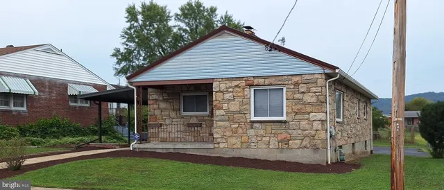 a view of a house with brick walls and a yard with windows