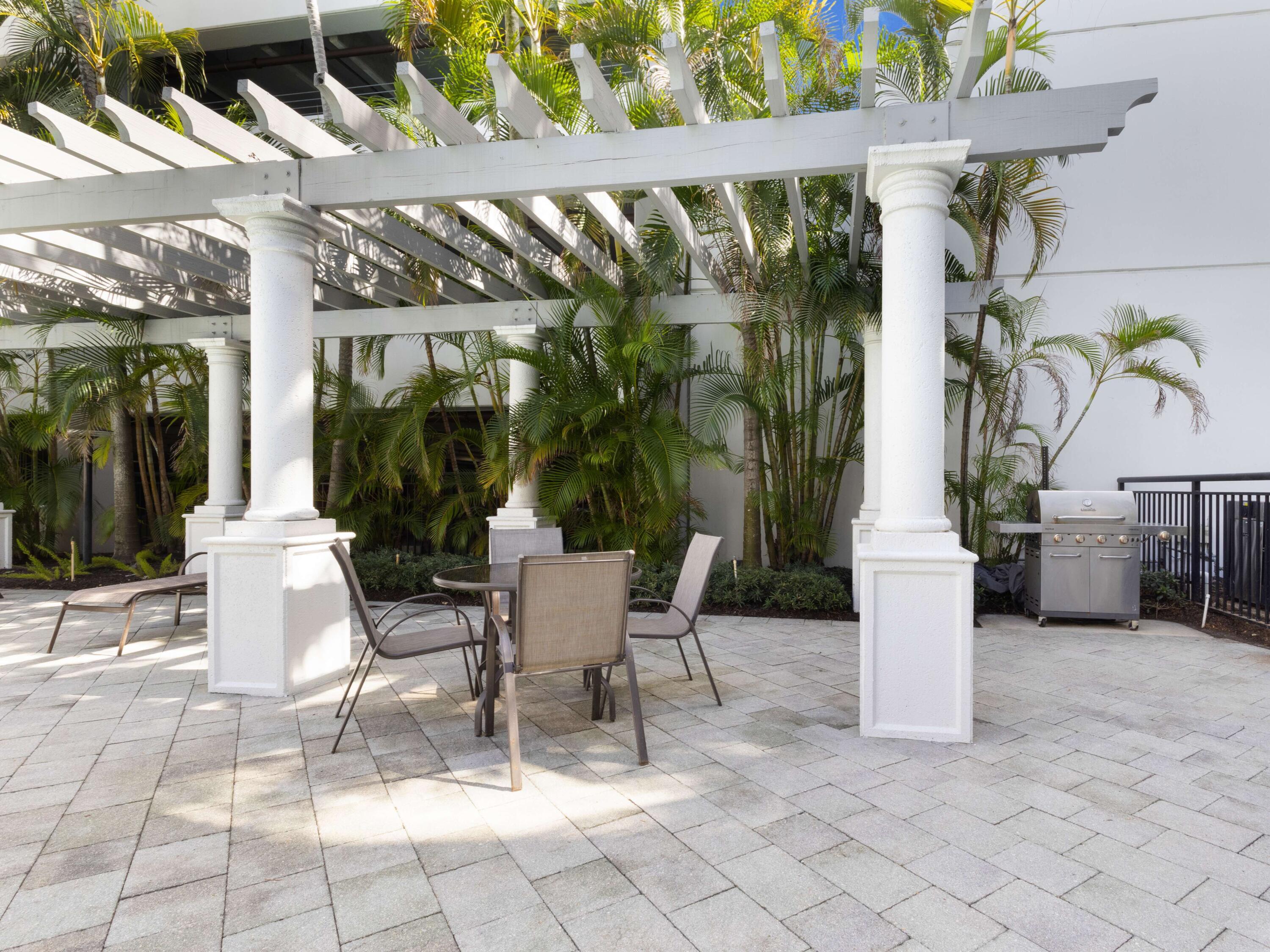 1690 Renaissance Commons Boulevard, Unit 1412 Boynton Beach, FL 33426 - Photo 33 of 49 a view of a patio with table and chairs