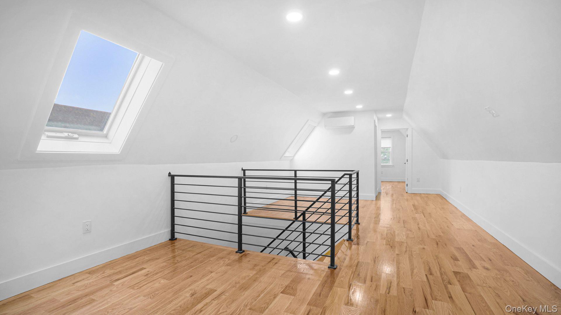 3968 Duryea Avenue Bronx, NY 10466 - Photo 17 of 30 Bonus room with a skylight, light wood-style flooring, lofted ceiling, recessed lighting, and a wall unit AC