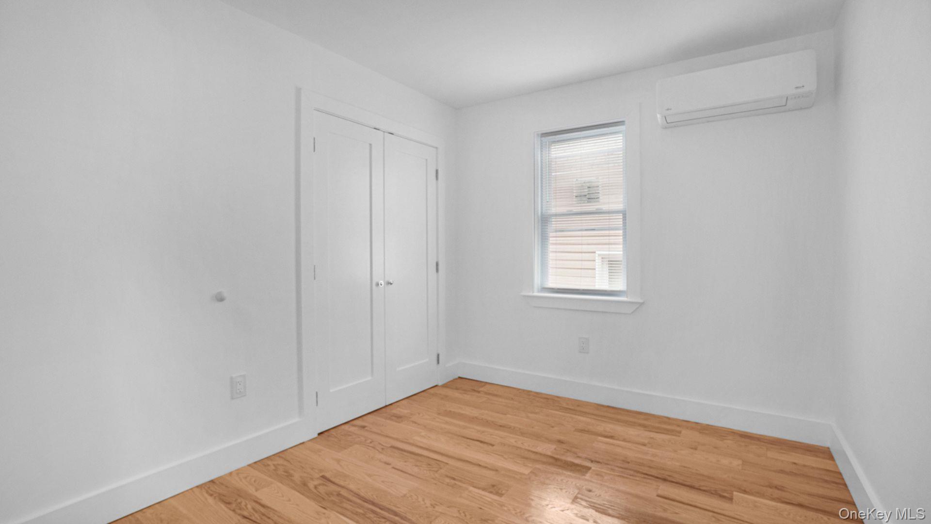 3968 Duryea Avenue Bronx, NY 10466 - Photo 18 of 30 Unfurnished bedroom featuring light wood-type flooring, a wall mounted air conditioner, and a closet