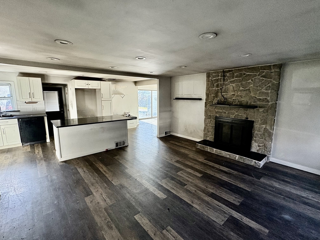 5 Wennerberg Road Middleton, MA 01949 - Photo 4 of 7 an empty room with wooden floor a fireplace and windows
