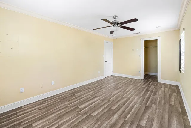 a view of a room with wooden floor and a ceiling fan