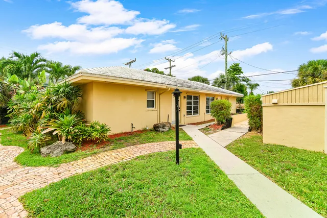 a view of a house with backyard and a tree