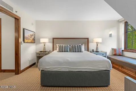 a large bed sitting in a bedroom next to a window