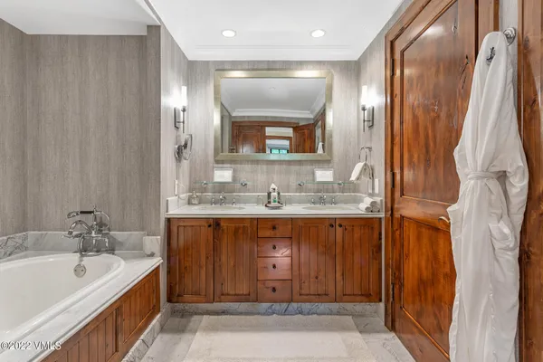 a bathroom with a granite countertop tub sink and mirror