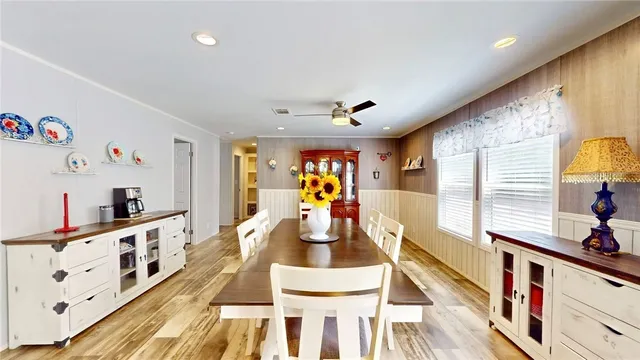 a view of a dining room with furniture a chandelier and wooden floor