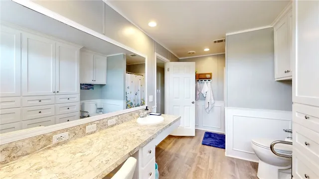 a spacious bathroom with a granite countertop sink mirror vanity bathtub and toilet