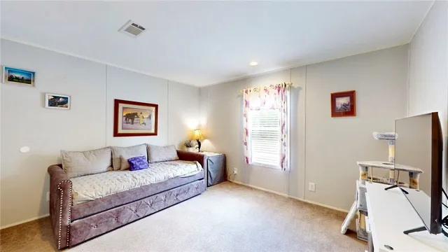 a living room with furniture a flat screen tv and a window
