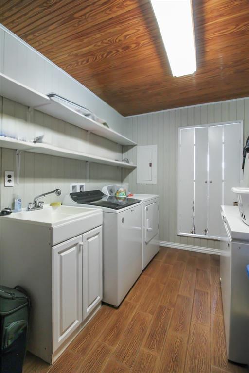 1001 Sandy Ridge Road Scurry, TX 75158 - Photo 20 of 35 Laundry area featuring wood-finish flooring, beadboard wall paneling, a utility sink with white cabinetry, and built-in shelving