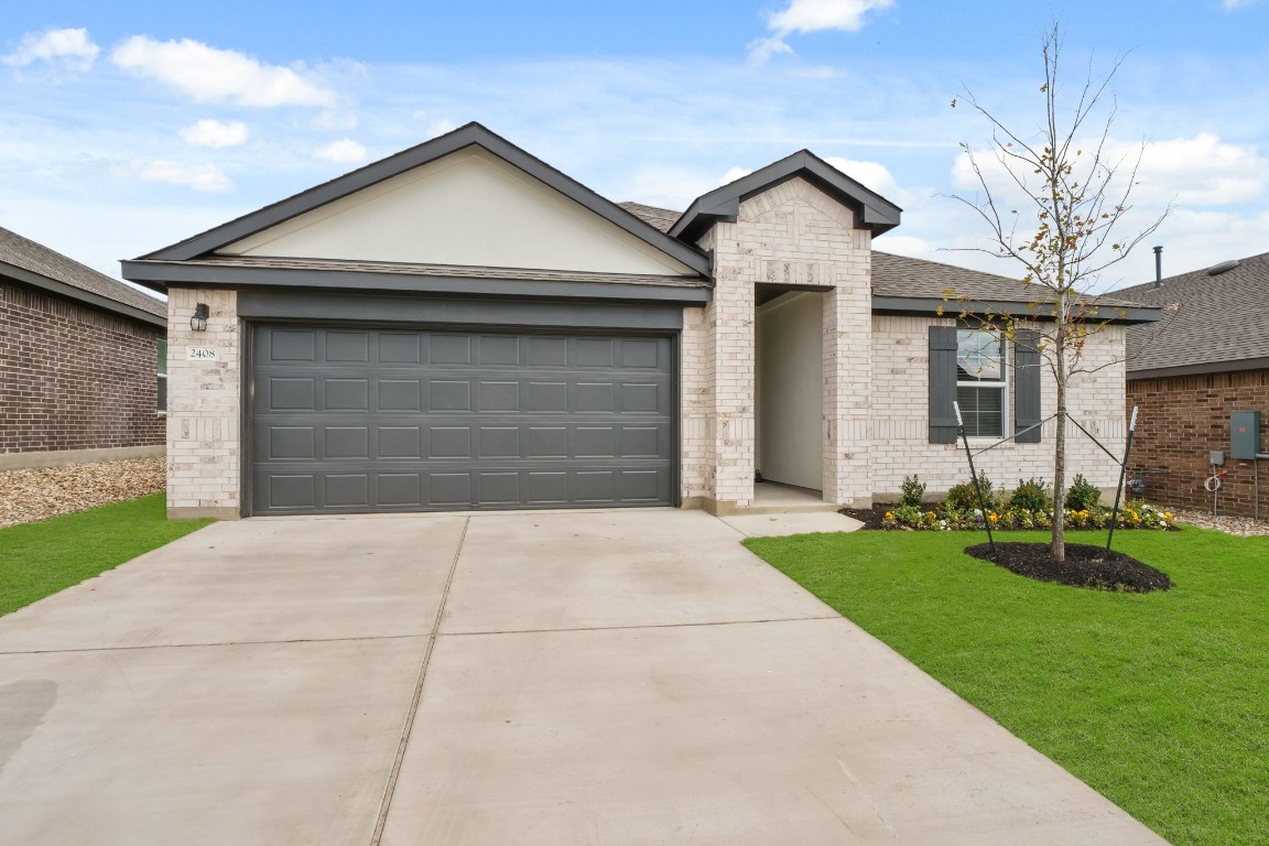 2408 Bronc Buster Way Leander, TX 78641 - Photo 1 of 24 a front view of a house with a yard and garage