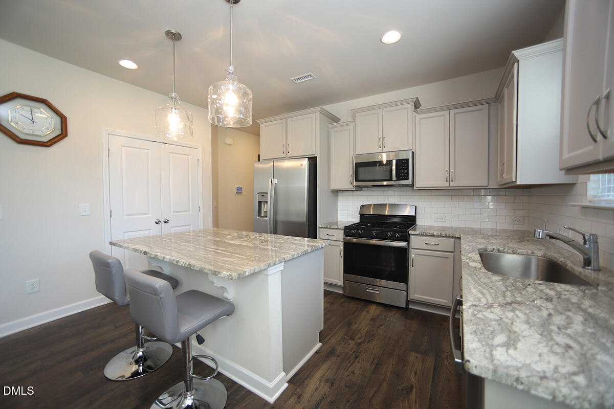 125 Mae Court Roxboro, NC 27573 - Photo 5 of 30 a kitchen with granite countertop wooden cabinets and stainless steel appliances
