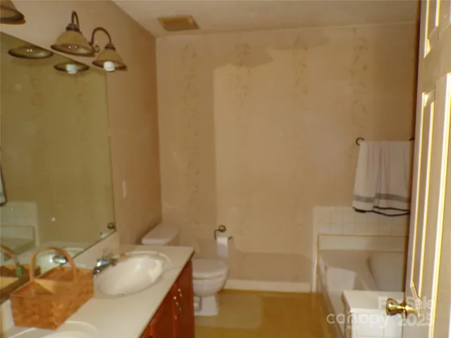 a bathroom with a granite countertop sink a toilet and shower