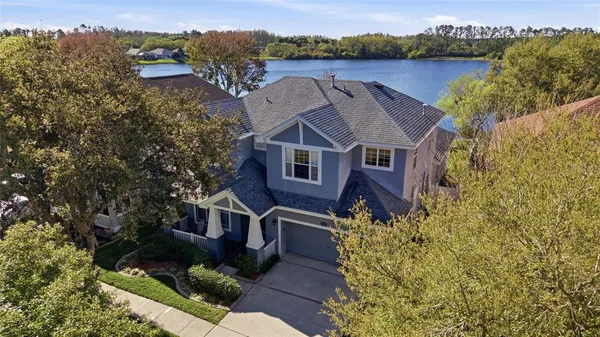 a aerial view of a house with a yard and large tree