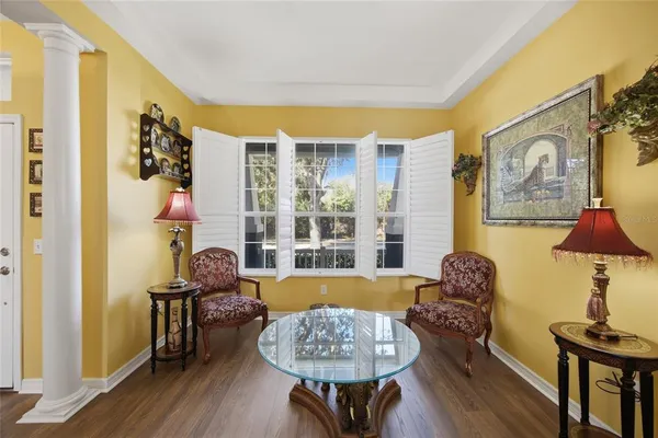 a living room with furniture floor to ceiling window and a flat screen tv