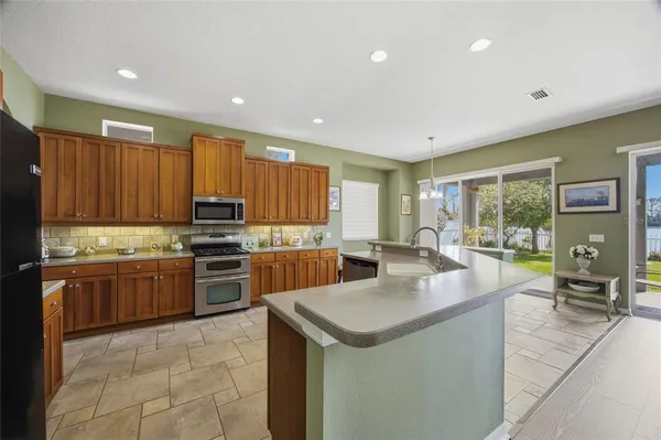 a kitchen with stainless steel appliances kitchen island granite countertop a sink and cabinets