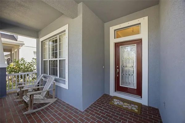 an empty room with wooden floor chandelier and windows