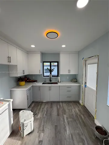 a large kitchen with a lot of counter space and a wooden floor