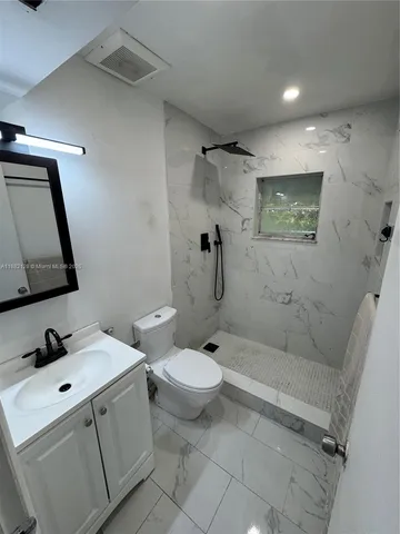a bathroom with a toilet sink and shower
