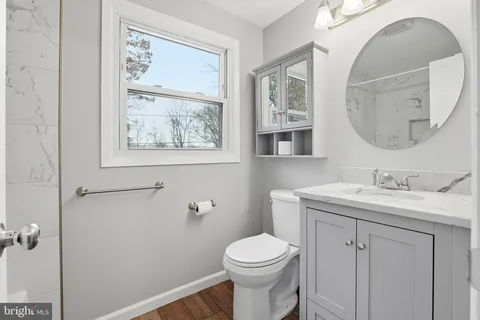 a bathroom with a toilet a sink and mirror