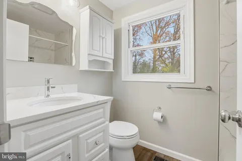 a bathroom with a sink a toilet and a window