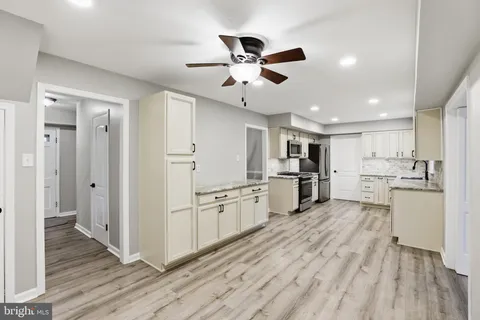 a kitchen with white cabinets and stainless steel appliances