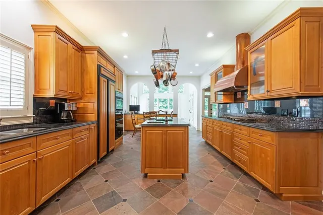 a kitchen with stainless steel appliances granite countertop a stove a sink and a refrigerator