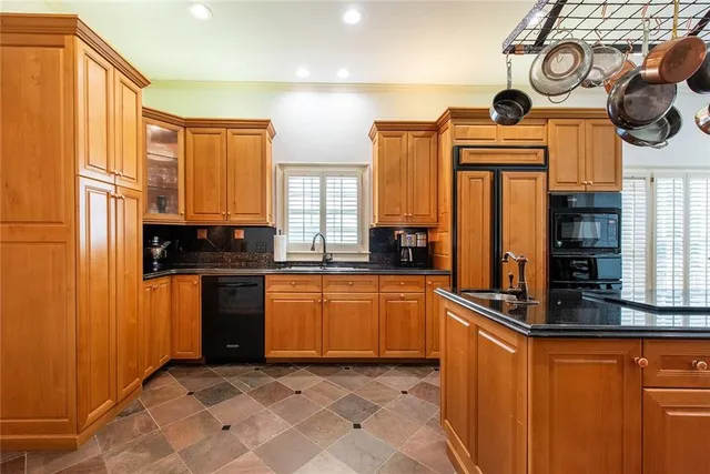 a kitchen with stainless steel appliances granite countertop a stove a refrigerator a kitchen island with a dining table and chairs