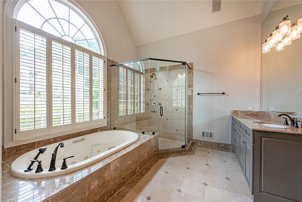 3854 Sidestreet Atlanta, GA 30341 - Photo 43 of 83 a bathroom with a tub a sink a mirror and a shower