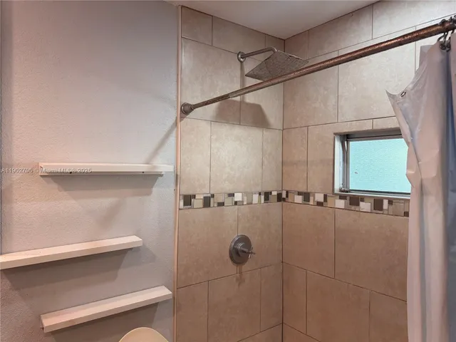 a bathroom with a shower and a sink