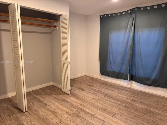 an empty room with wooden floor and a door