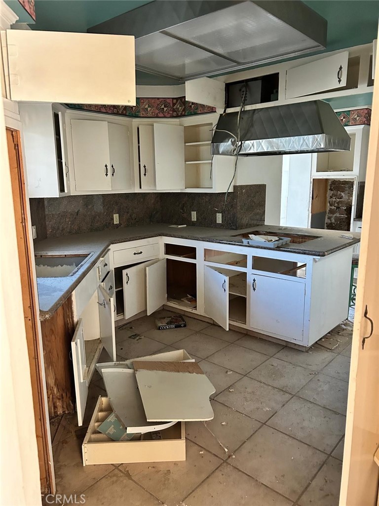 20572 Rancherias Road Apple Valley, CA 92307 - Photo 4 of 11 a kitchen with a stove and white cabinets