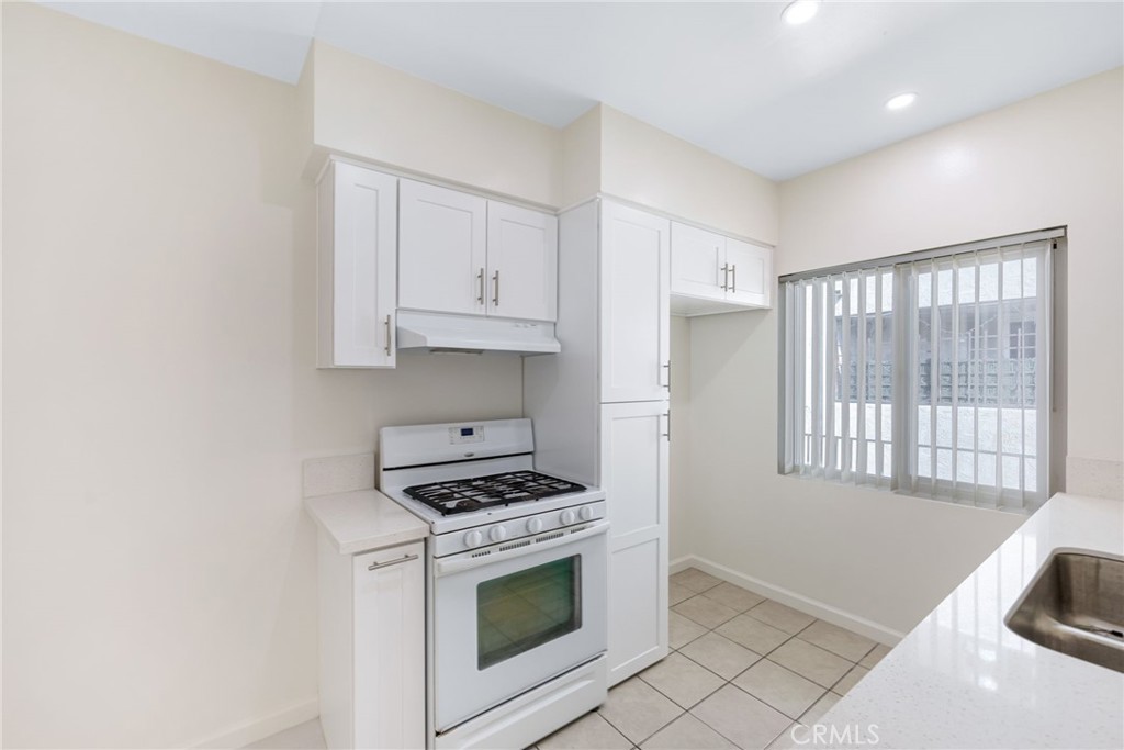 580 West Stocker Street, Unit 6 Glendale, CA 91202 - Photo 8 of 17 a kitchen with granite countertop white cabinets and white appliances