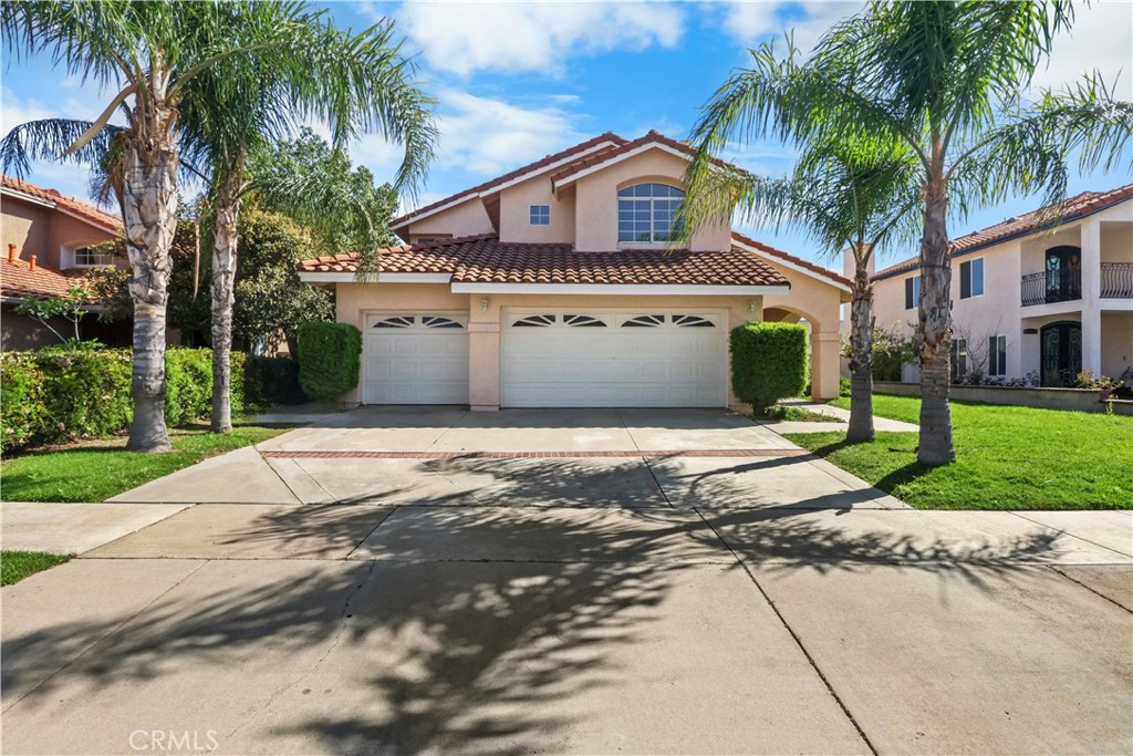 11189 Summerside Lane Rancho Cucamonga, CA 91737 - Photo 2 of 30 a view of a white house with a large tree and a yard in front of it