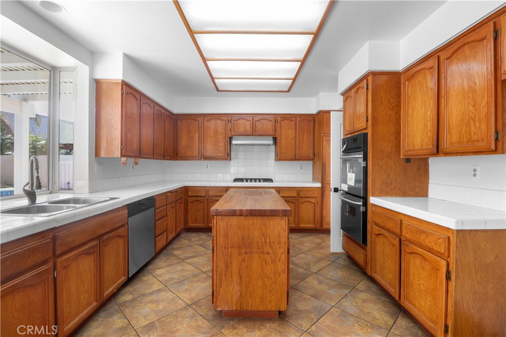11189 Summerside Lane Rancho Cucamonga, CA 91737 - Photo 9 of 30 a kitchen with stainless steel appliances granite countertop wooden cabinets a sink and dishwasher a stove with wooden cabinets