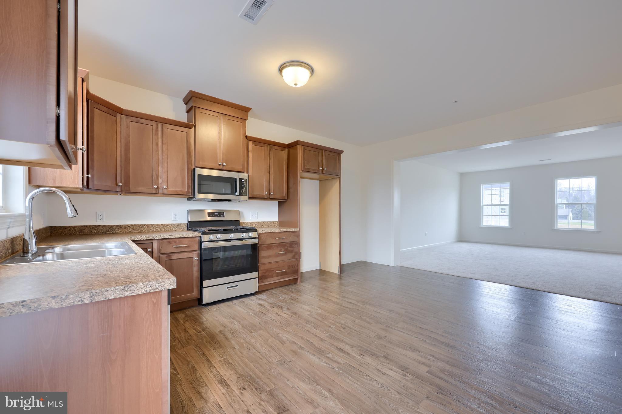 2417 Spring Water Circle Lancaster, PA 17601 - Photo 17 of 35 a kitchen with granite countertop a refrigerator stove top oven and sink