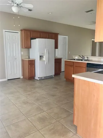 a view of kitchen with refrigerator and cabinets
