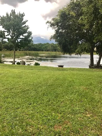 a view of yard with swimming pool and green space