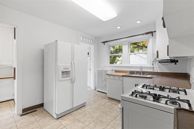 a kitchen with granite countertop white cabinets and white appliances