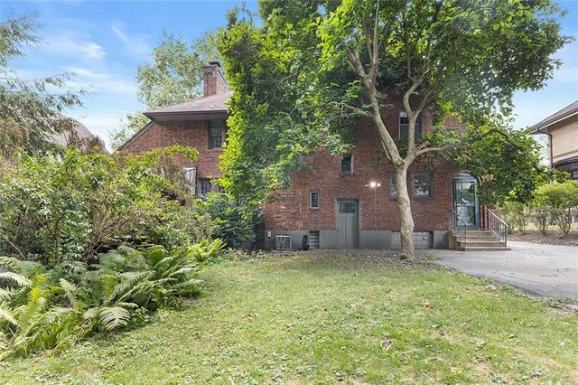 a view of a house with backyard and trees
