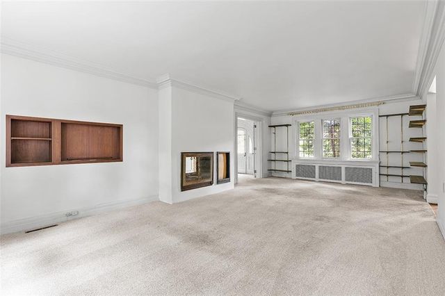 a view of an empty room with a fireplace and a window