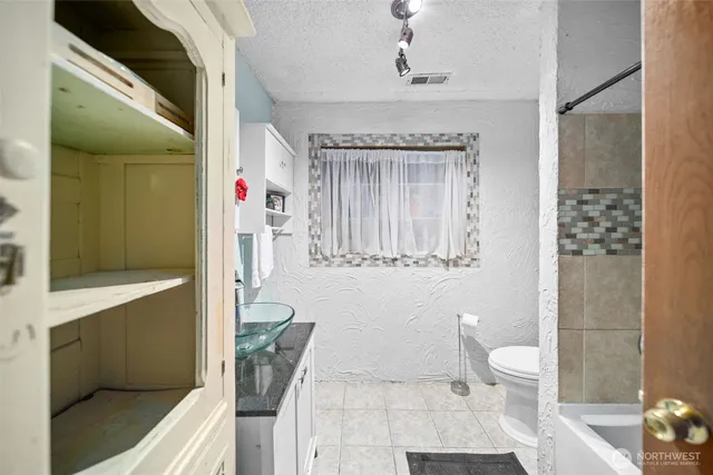 a bathroom with a sink a toilet and shower