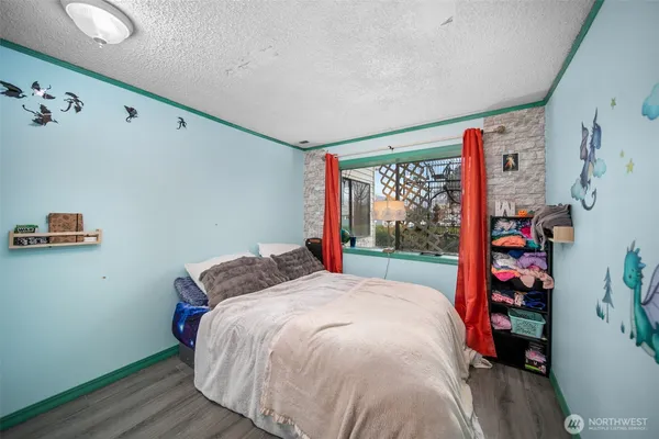 a bed sitting in a bedroom next to a window