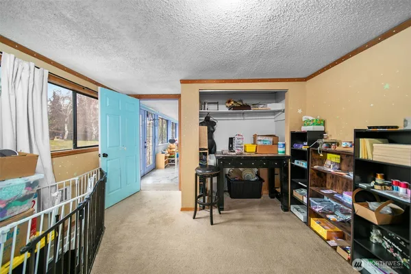 a living room with furniture a bookshelf and a window