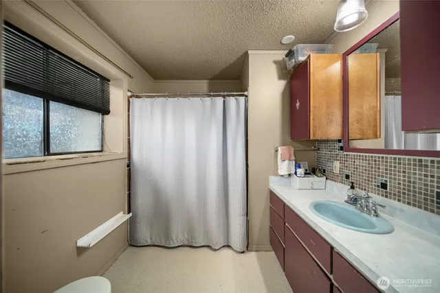 a bathroom with a granite countertop sink toilet and shower
